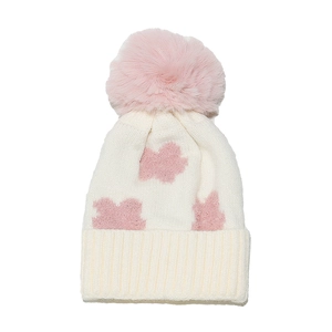 Close-up of knit winter hat showing soft pink plush pom-pom and flower jacquard pattern