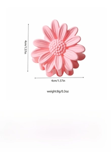 Detail showing a pink daisy hair claw clip with 4cm diameter and matte resin texture