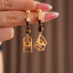Detail of vintage gold chair earrings with tiger eye beads and smiley face charms