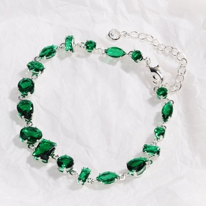 Macro detail of multi-shape green zircon stones on silver bracelet with adjustable clasp