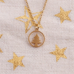 Polierte goldene Edelstahl-Weihnachtsbaum-Halskette auf festlichem Sternenstoff