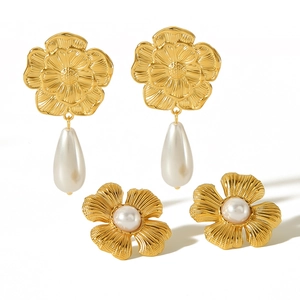 French style 18k gold flower earrings set with drop and round pearls on white background