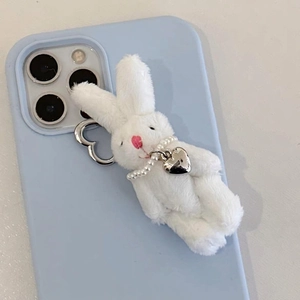 Cute white plush bunny keychain with pearl necklace and silver heart on a blue phone