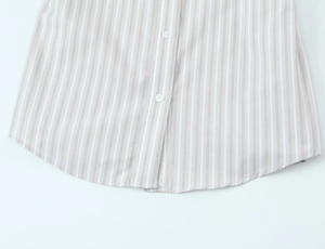 Vue détaillée de l'ourlet de chemise à rayures grises avec coutures et boutons blancs