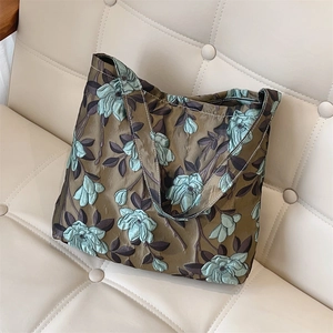 Dettaglio del tessuto jacquard floreale verde scuro vintage di una piccola borsa a tracolla