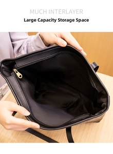 Close-up of the large black tote bag interior showing multiple layers and zipper pocket