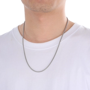 Close-up of a silver wheat chain necklace worn on a male model's neck for fashion styling