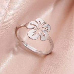 Minimalist silver stainless steel open flower ring on soft pink silk background