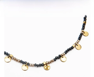 Detailed close-up of beaded necklace with faceted grey stones and gold round charms