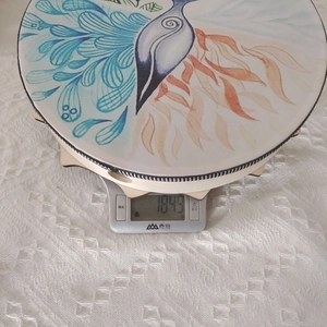 Detail view of a wooden Independence Day drum ornament on a scale weighing 184.9g