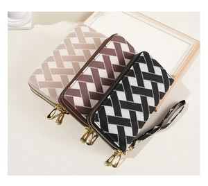 Detail of three striped wallets with double gold zippers and detachable wrist straps