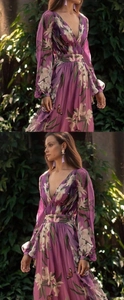 Détail d'une robe longue fleurie violette avec col en V élégant et manches longues
