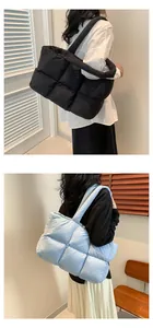 Detail of quilted puffer tote bag showing large square stitching and padded texture