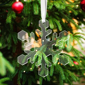 Transparent acrylic snowflake ornament hanging on a Christmas tree with white ribbon cord