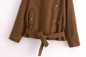 Detail of a brown short wool jacket featuring a matching waist belt and double-breasted buttons