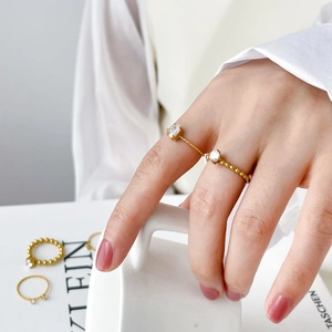 Close-up of 18K gold plated rings with oval and round zircon stones on a model's finger