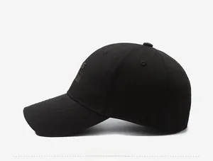 Detail view of black cotton baseball cap with brown side letter embroidery