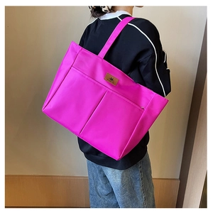 Rose red nylon tote bag shown in a real-life back view to display size and fit