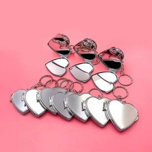 Porte-clés miroir pliable en forme de cœur argenté avec finition métallique sur fond rose