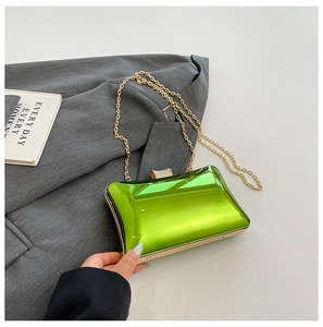 Makro-Detail der hellgrünen Hartschalen-Clutch mit Goldkette und Diamantverschluss