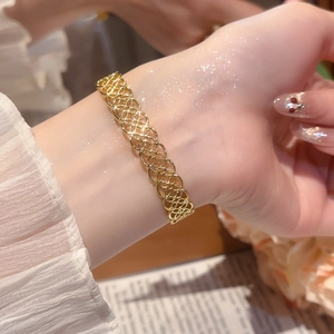 Vue détaillée d'un bracelet ajouré doré avec un motif complexe de maille en losange tissé