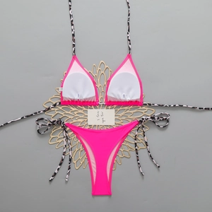 Detail view of pink bikini top lining with leopard print straps on a floral decor base