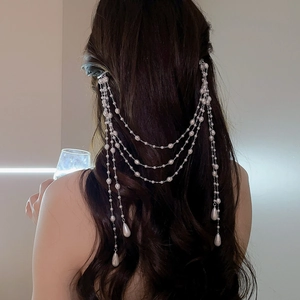 Elegant multi-layer pearl fringe hair chain with teardrop pendants on wavy brown hair