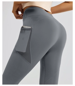 Detail of high waist yoga pants showing side mesh pocket holding a smartphone
