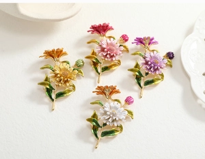 Detailed macro view of colorful daisy brooches in yellow, pink, violet, and white enamel