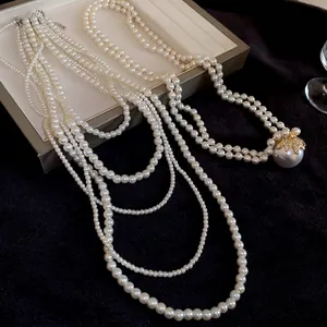 Elegant multi-layer cream pearl necklace with gold star pendant on a velvet background