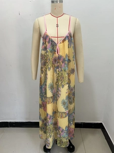 Close-up of bohemian yellow floral maxi dress with delicate pink straps and V-neckline