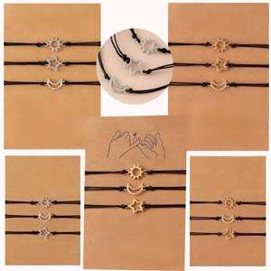Close-up of Sun Moon Star friendship bracelets on kraft paper cards with woven wax cords