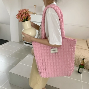 Dettaglio borsa shopper rosa con trama a bolle, etichetta LOVE SOZAKKA e tracolla larga