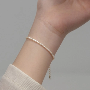 Elegante pulsera de perlas de agua dulce con cadena dorada ajustable en la muñeca