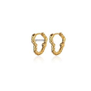 Detail of 13mm gold heart hoop earrings featuring irregular lava texture on white base
