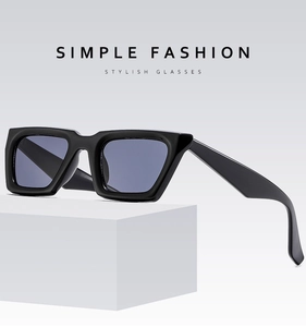 Detail view of stylish thick black square sunglasses frame with grey blue lenses on display