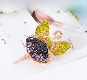 Detailed macro shot of vintage ballet girl brooch with colorful rhinestones on gold frame