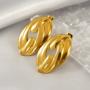 18K gold plated stainless steel hollow twisted hoop earrings on silk background