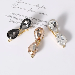 Three elegant crystal bow hair clips in champagne, grey and white on gold metal base
