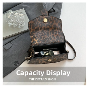 Detail view of leopard print crossbody bag interior showing storage space for cosmetics