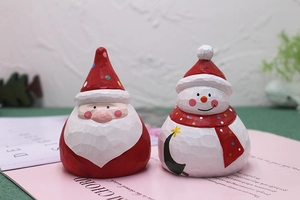 Close-up of hand-painted wooden Santa Claus and Snowman figurines for Christmas decor