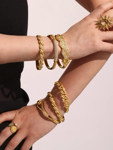 Dettaglio di bracciali placcati in oro 18k con dettagli in zirconia e motivi geometrici