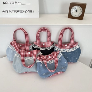 Dettaglio di mini borse in denim con bordi a quadretti rossi e finiture in pizzo