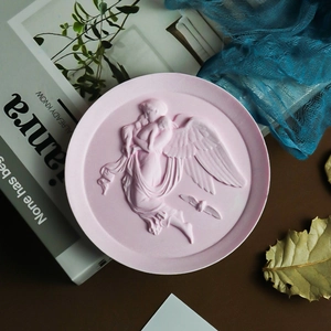 Detailed relief of angel and baby on a pink decorative round tray with artistic props