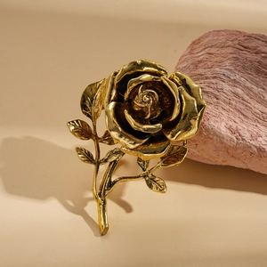 Macro shot of vintage gold rose petal textures and metallic leaf details on a leather surface