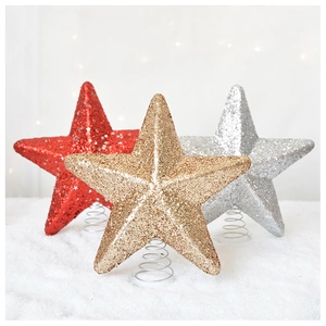 Close-up of sparkling red and gold star tree toppers with silver spring bases on snow