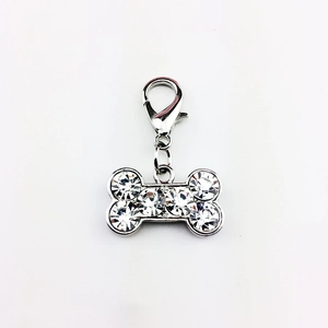 Close-up of sparkling rhinestone-studded dog bone charm with silver lobster clasp