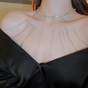 Detail view of a long gold rhinestone shoulder chain and body jewelry for bridal dress