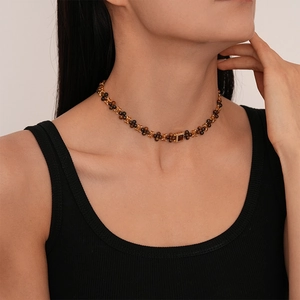 Macro detail of Maillard style beaded necklace with square brown zircon pendant on model