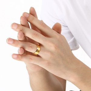 Close-up of a 8mm wide polished gold tungsten ring on a male model hand with white background